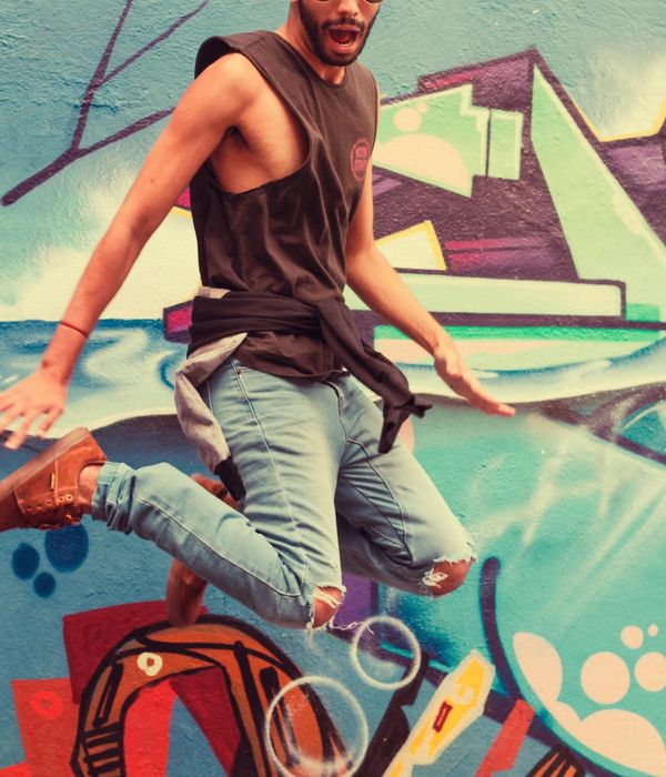 Team member portrait with neon spray border and graffiti background